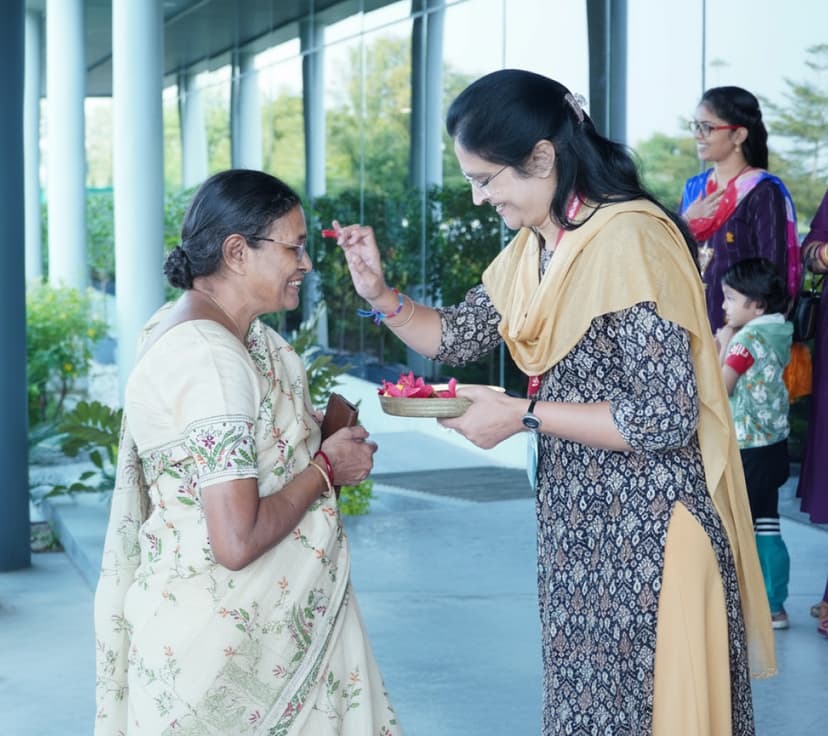 A teacher welcoming a family member with flower petals at Global Guardians School